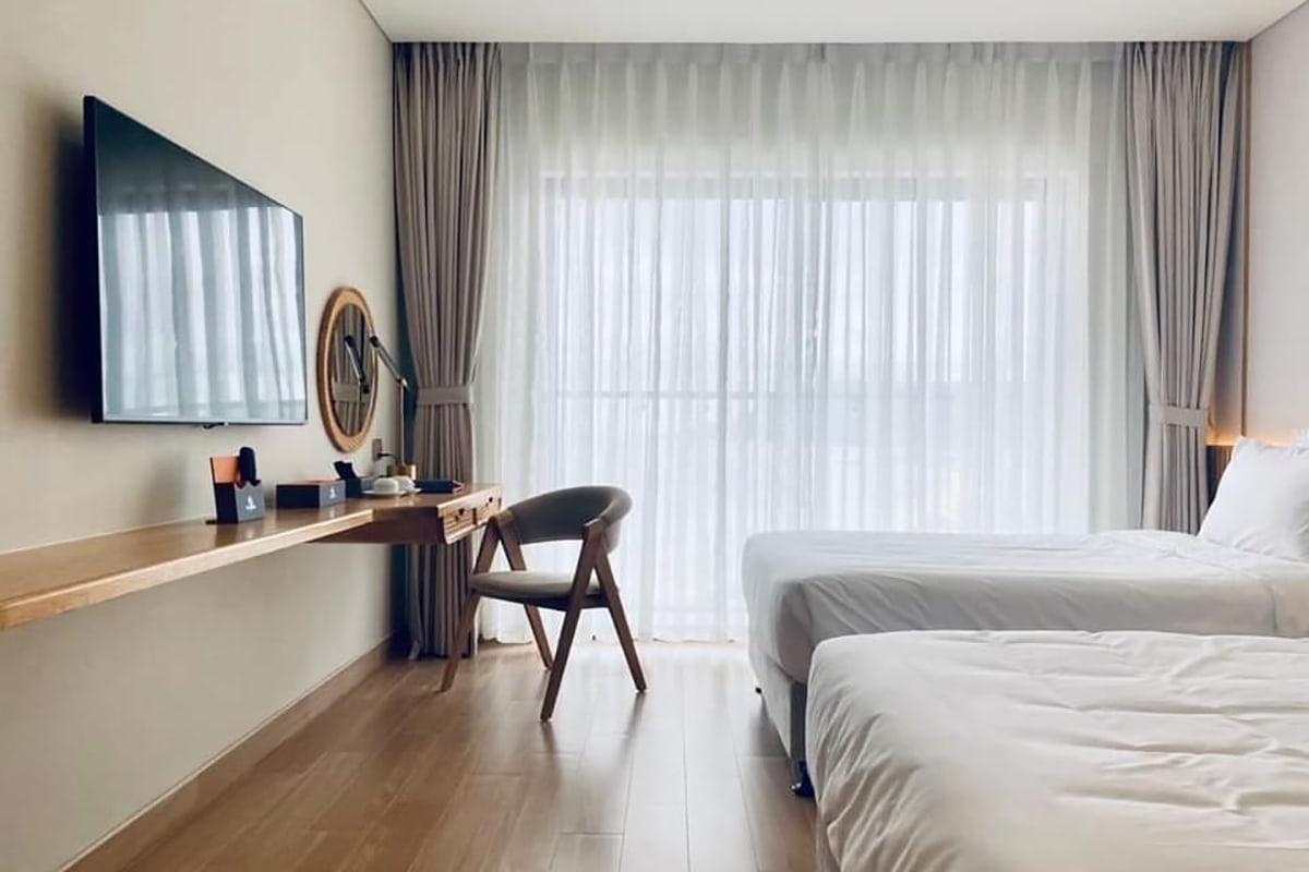 Double room at Seabird Hotel Thien Cam with two beds television and large window